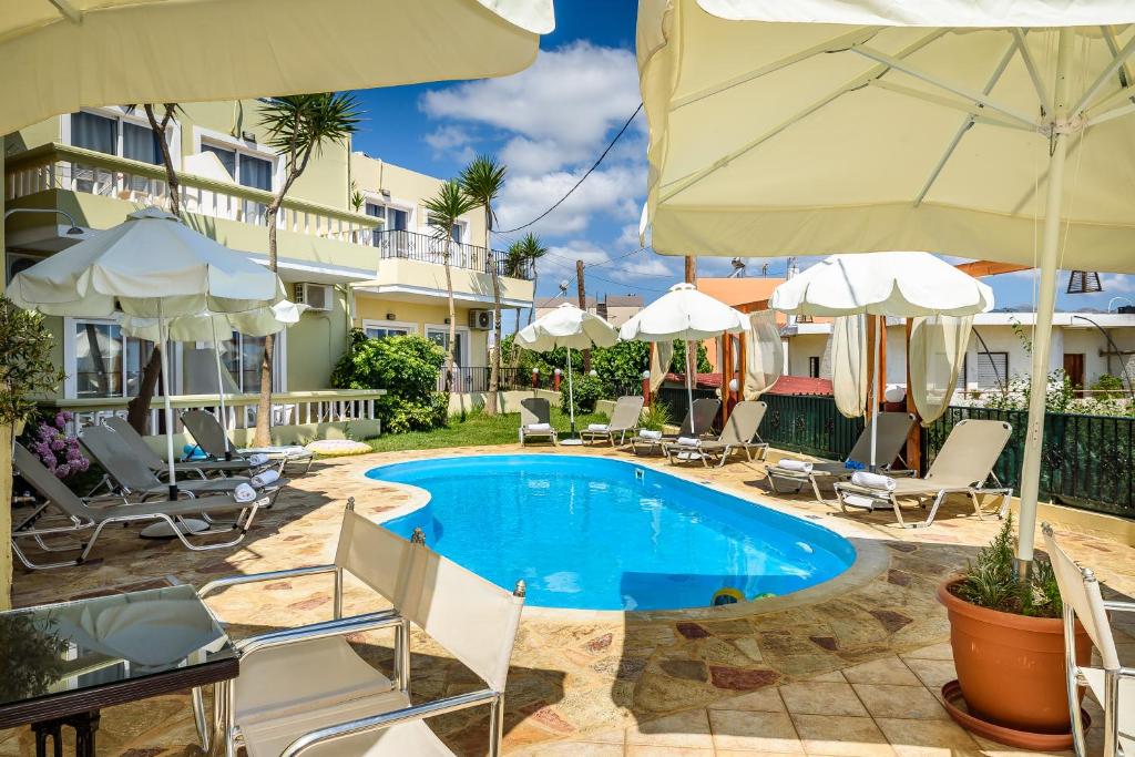 uma piscina num hotel com cadeiras e guarda-sóis em Irinoula Dreams em Kolymvari