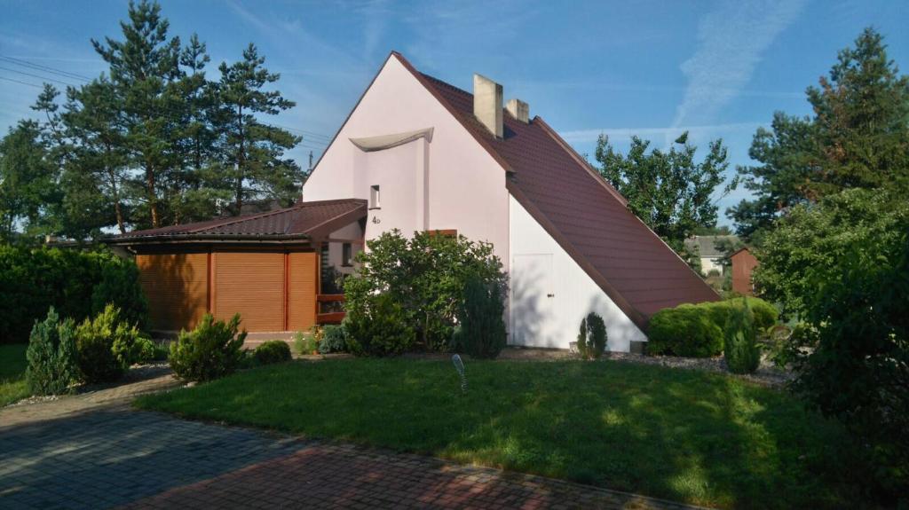 una pequeña casa blanca con techo marrón en 4 D klima en Licheń
