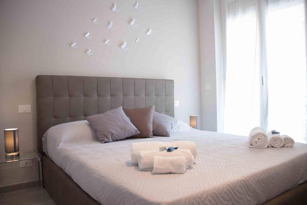een slaapkamer met een groot bed en handdoeken bij Le 3B - Finalpia in Finale Ligure