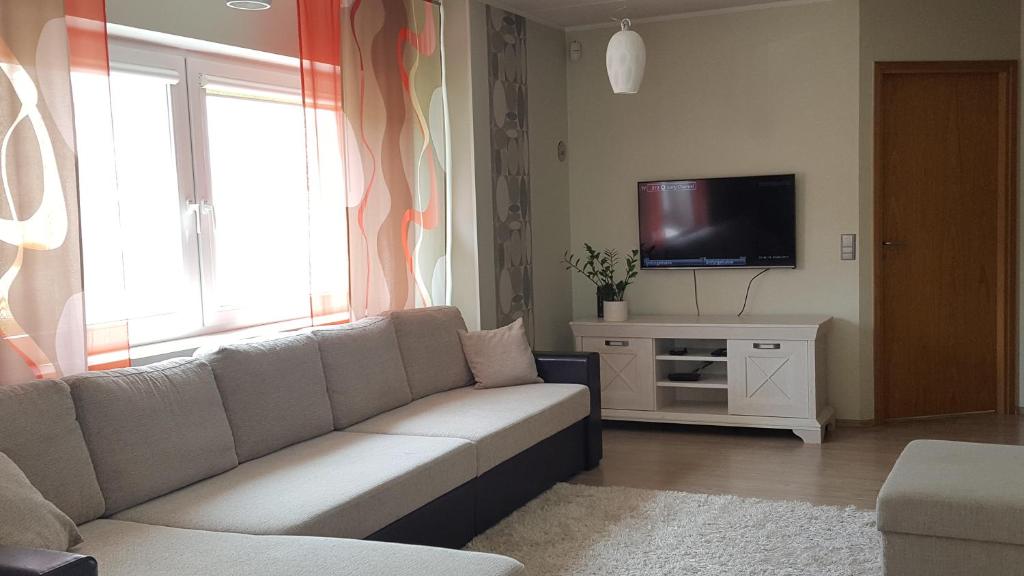 Una sala de estar con un sofá y un televisor. en Mai 59 Apartment, en Pärnu