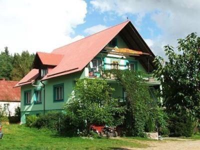 zielony dom z czerwonym dachem w obiekcie Agroturystyka Zielone Wzgorze w mieście Sikorzyno