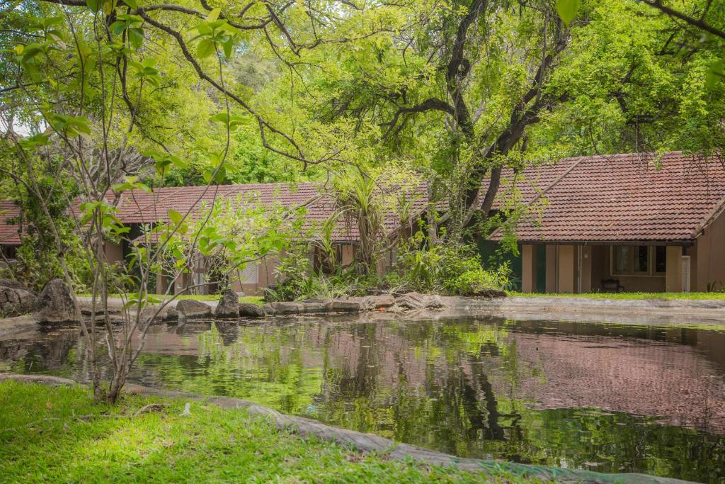 a house with a pond in front of it at Sigiriya Village in Sigiriya