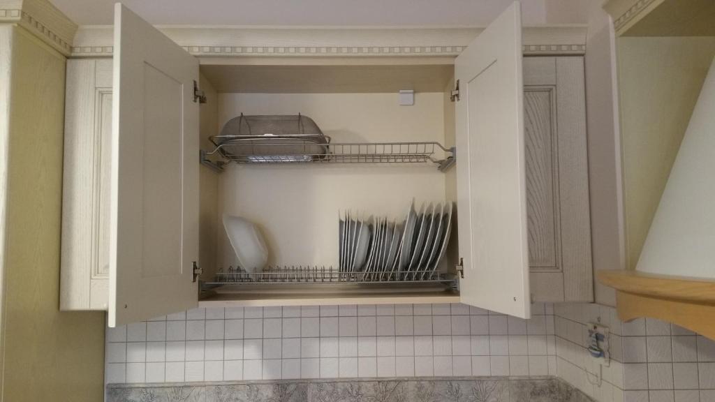 une cuisine avec un placard rempli de vaisselle dans l'établissement Laura's Home, à Durrës