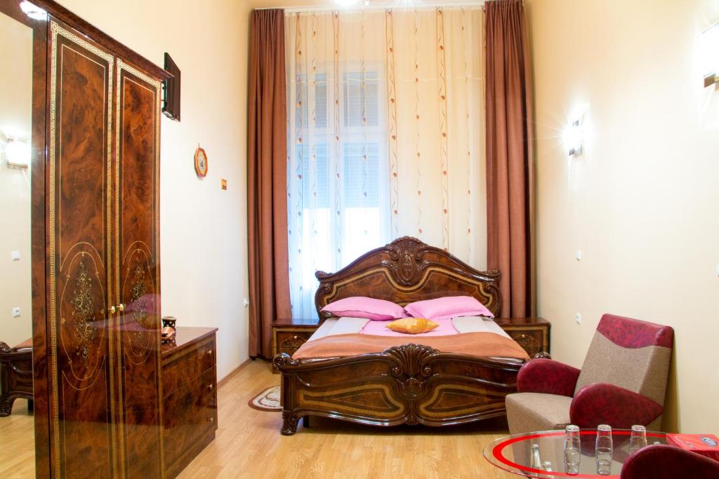 Un dormitorio con una cama con almohadas rosas y una ventana en Garsoniera Alegna, en Sibiu