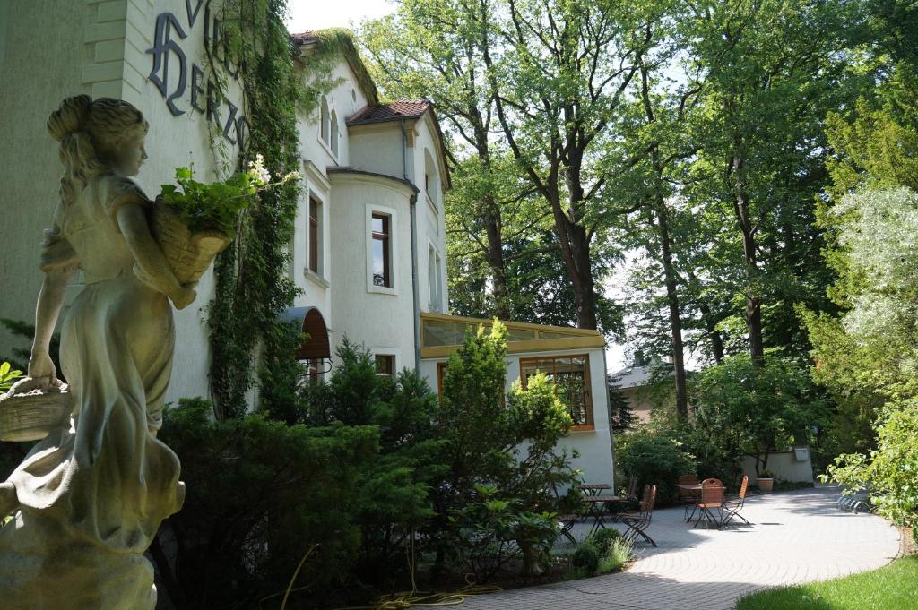 une statue d'une femme debout devant un bâtiment dans l'établissement Hotel Villa Herzog, à Dresde