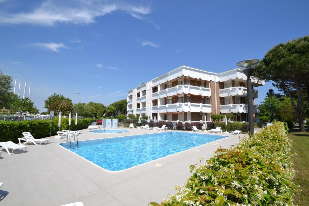 un hotel con piscina di fronte a un edificio di Gavitello a Bibione