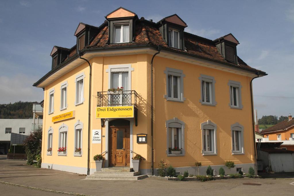 un petit bâtiment jaune avec un toit dans l'établissement Gasthaus drei Eidgenossen, à Bischofszell
