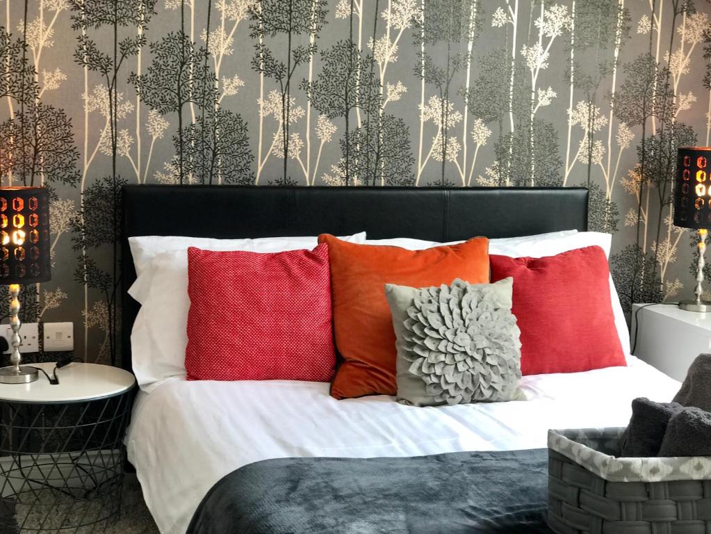 a bed with red and orange pillows in a bedroom at Loft Living Oxford in Oxford