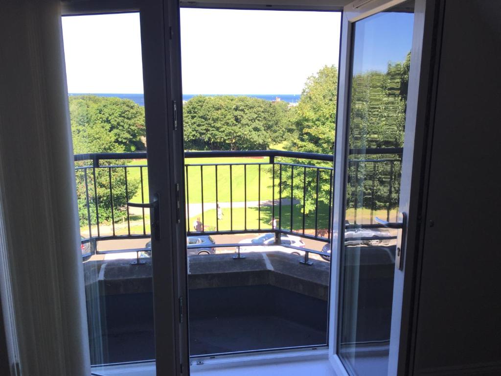 a sliding glass door with a view of a tub at Sea View Apartments in South Shields