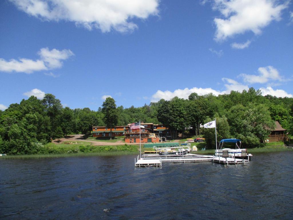 a group of boats docked on a lake with a house at AJ's Lodge and Oven in Bergland