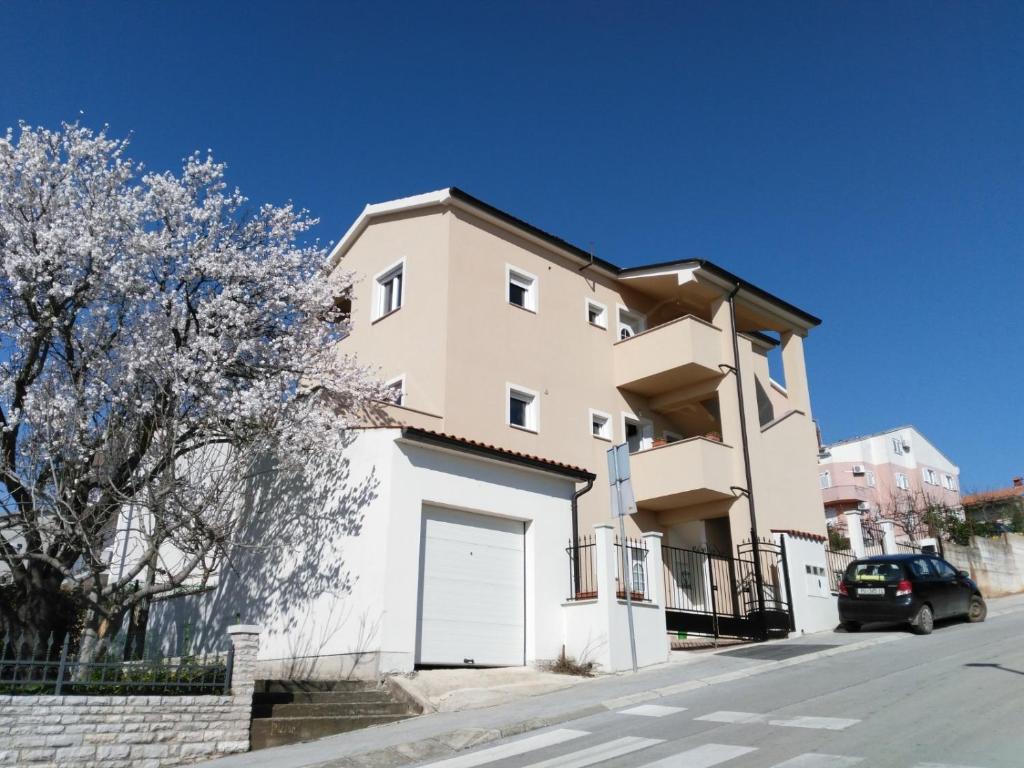 un edificio blanco con garaje en una calle en Apartments Explore Istria 4, en Pula