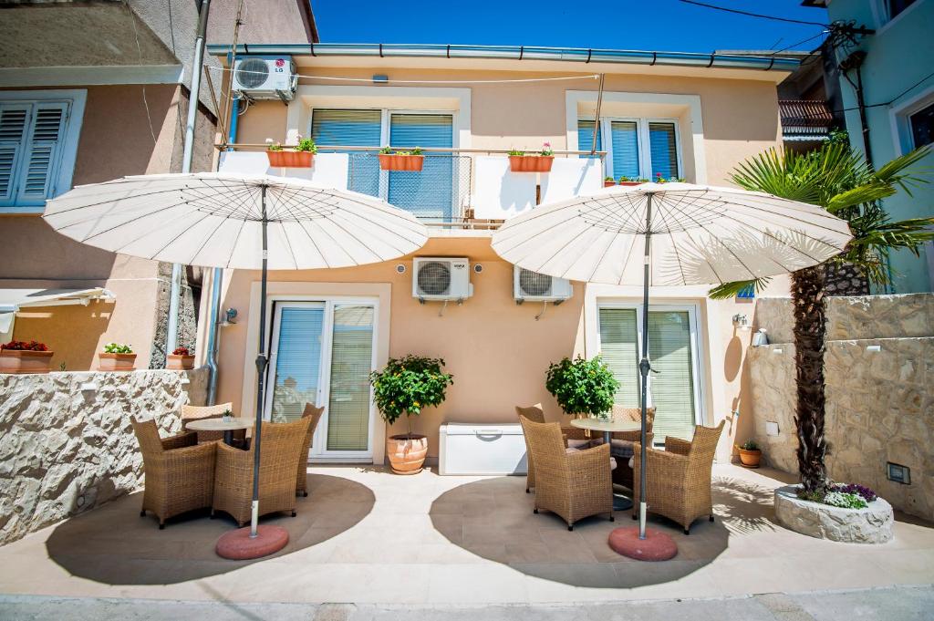 patio z 2 parasolami, stołem i krzesłami w obiekcie Sebenicum Apartments w Szybeniku