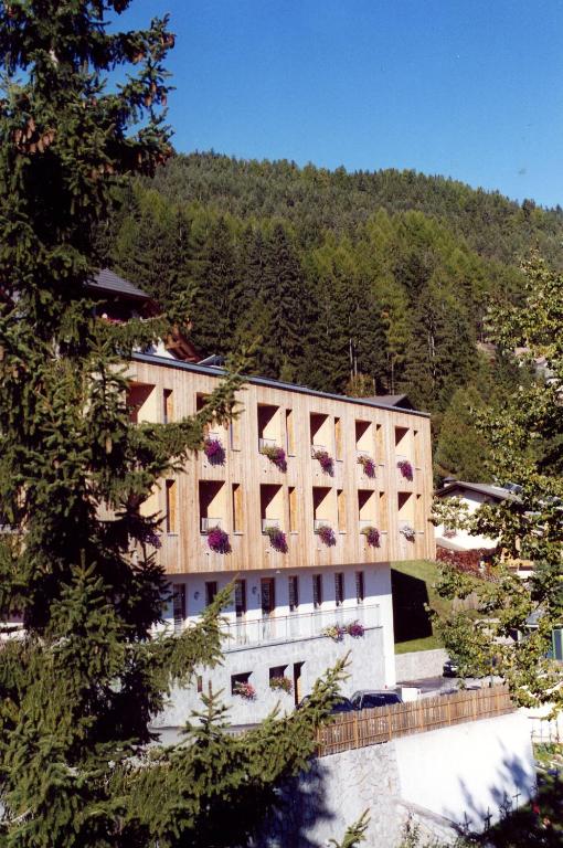 a building with flowers on the side of it at Al Cargà in San Vigilio Di Marebbe