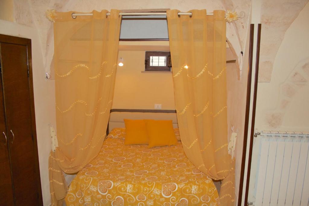 チェーリエ・メッサーピカにあるCasa Jennyのベッドルーム1室(黄色い枕とカーテン付きのベッド1台付)