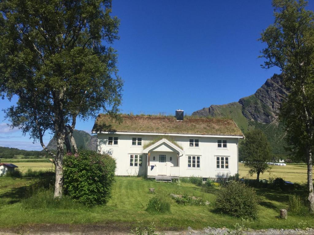 una casa blanca con una montaña en el fondo en Steigen Lodge Villa Vaag, en Steigen