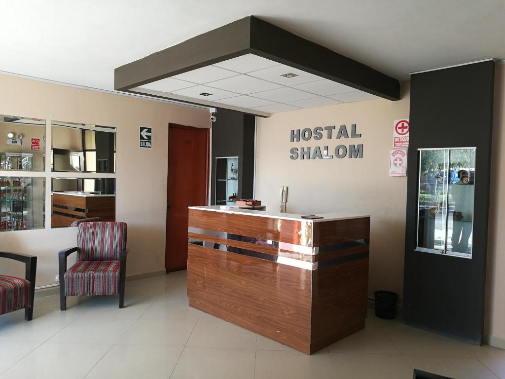 a hospital lobby with a reception desk and a hospital window at Hostal Shalom in Pisco