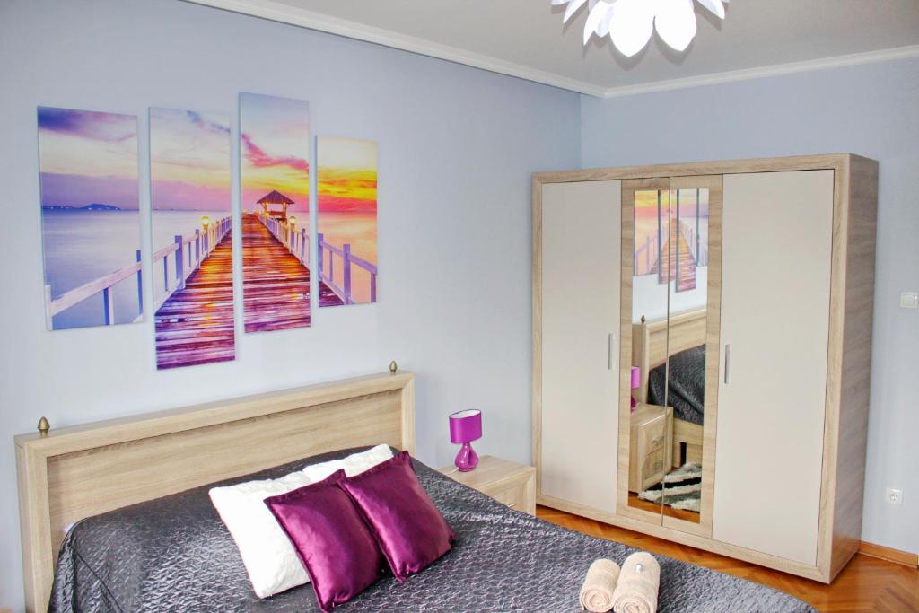 a bedroom with a bed and a painting of a pier at Kristi Lux Apartment Center Free Parking Fast WiFi in Belgrade