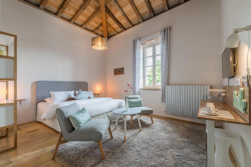 PuylaurensにあるCap de Castelのベッドルーム1室(ベッド1台、テーブル、椅子付)