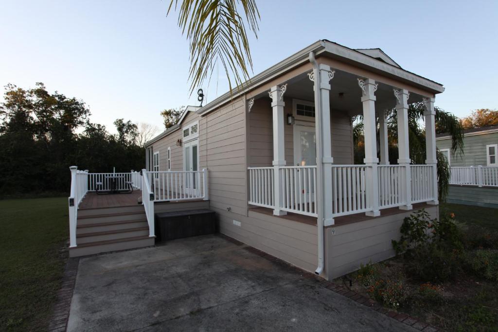 Cette petite maison dispose d'une terrasse couverte et d'une terrasse blanche. dans l'établissement Orlando RV Resort, à Orlando