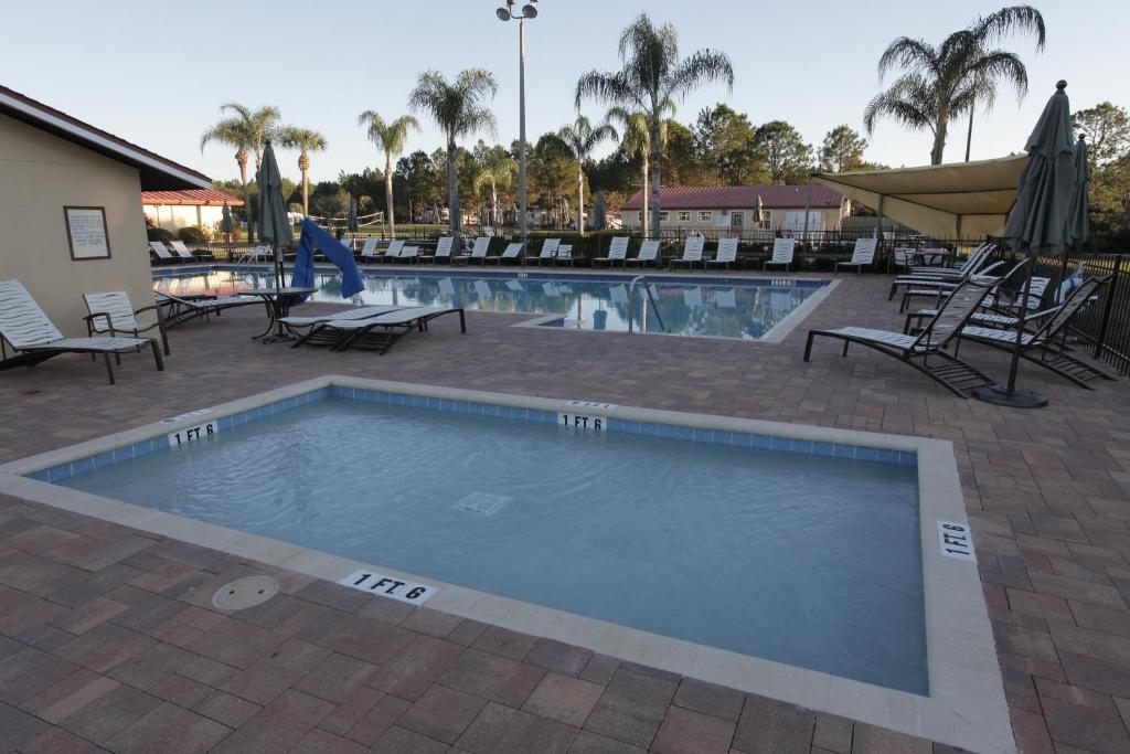 a pool at a resort with chairs and a slide at Orlando RV Resort in Orlando