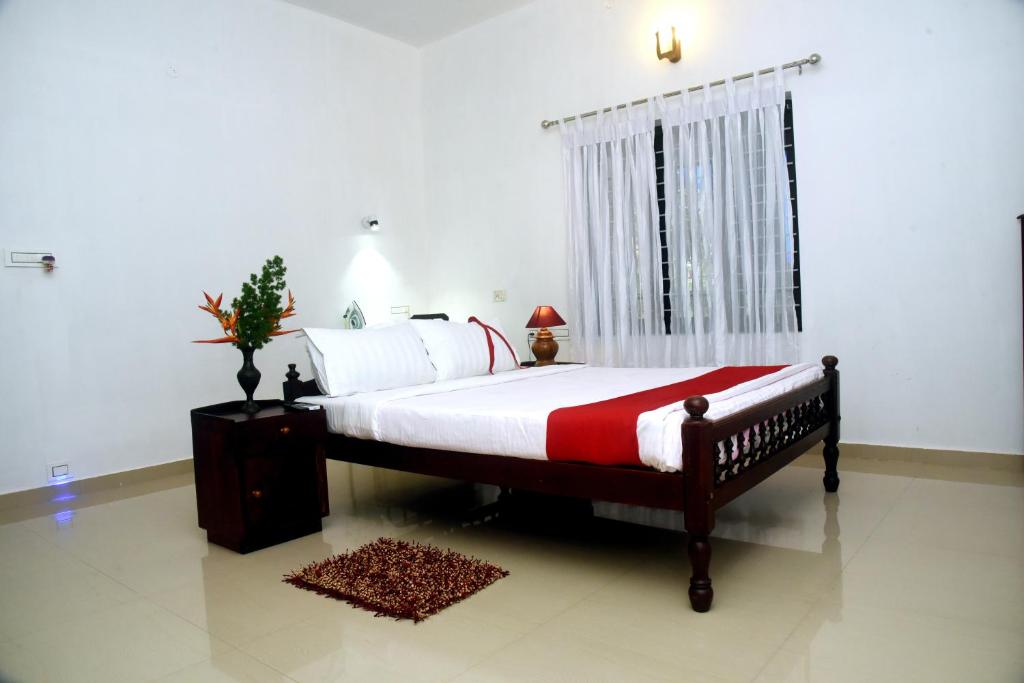 a bedroom with a large bed and a window at Marari Bethsaida Homestay in Shertallai