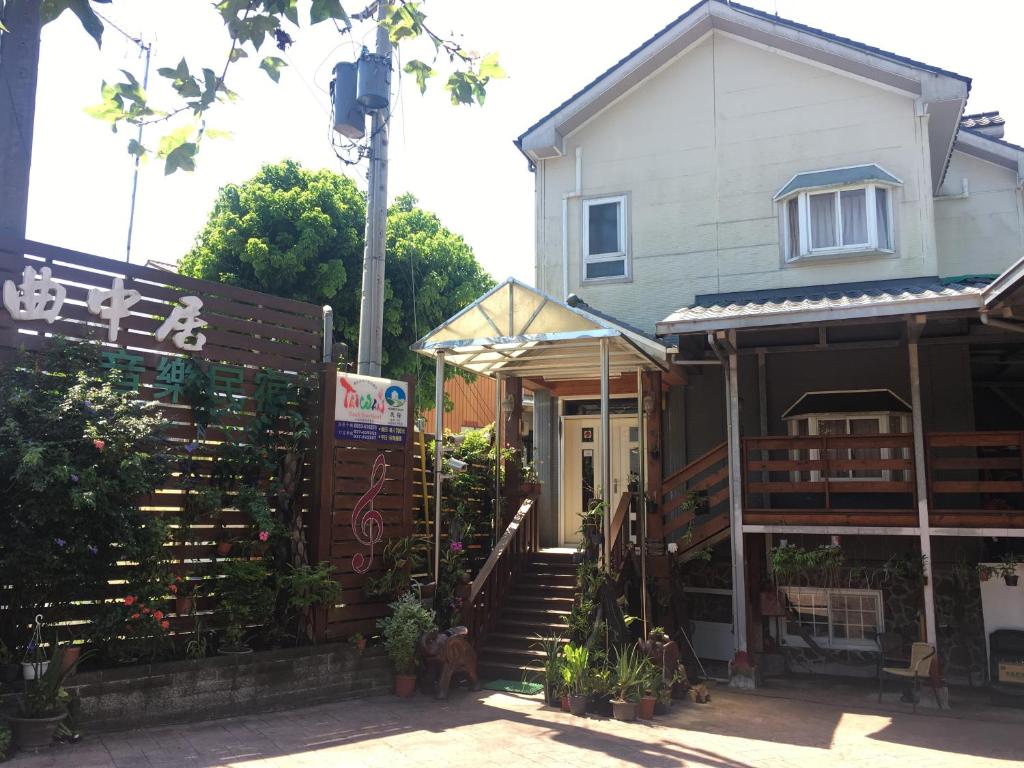 uma casa com uma escada em frente em Music House Homestay em Nanzhuang