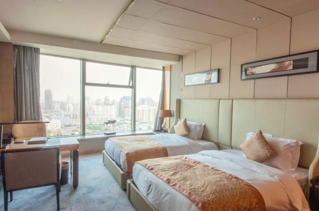 Un pat sau paturi într-o cameră la Tangla Hotel Tianjin