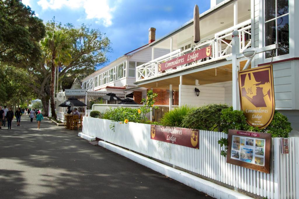 a building on a street with people walking in front of it at Commodores Lodge in Russell