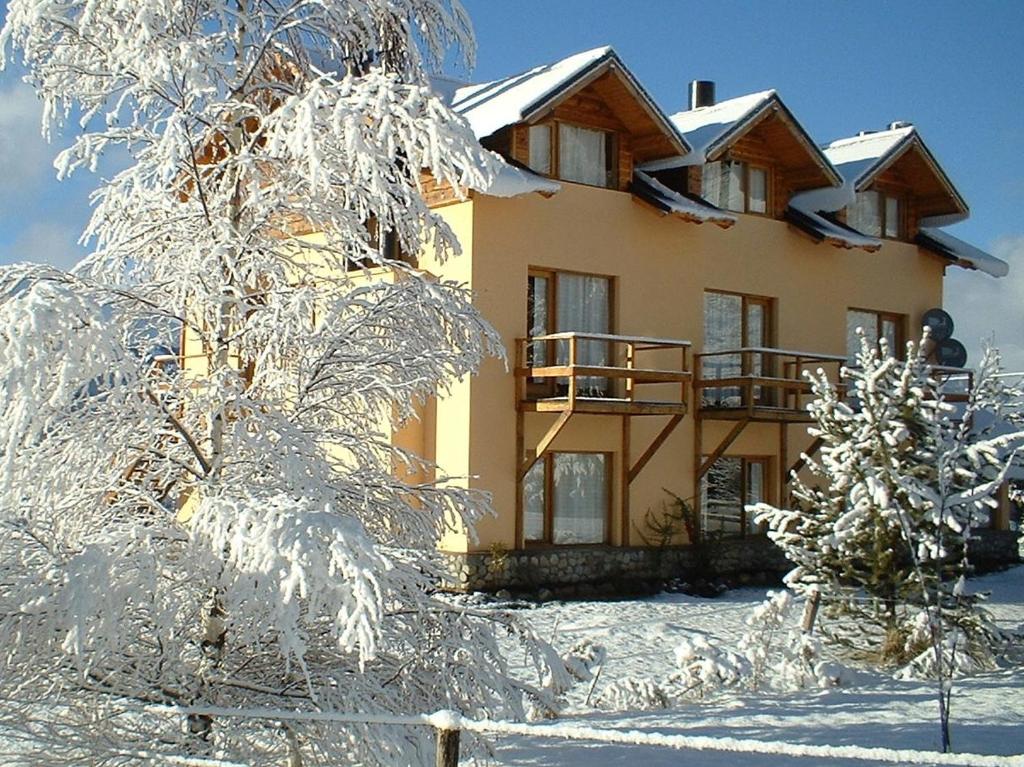 a house with snow covered trees in front of it at Gradocero in San Carlos de Bariloche