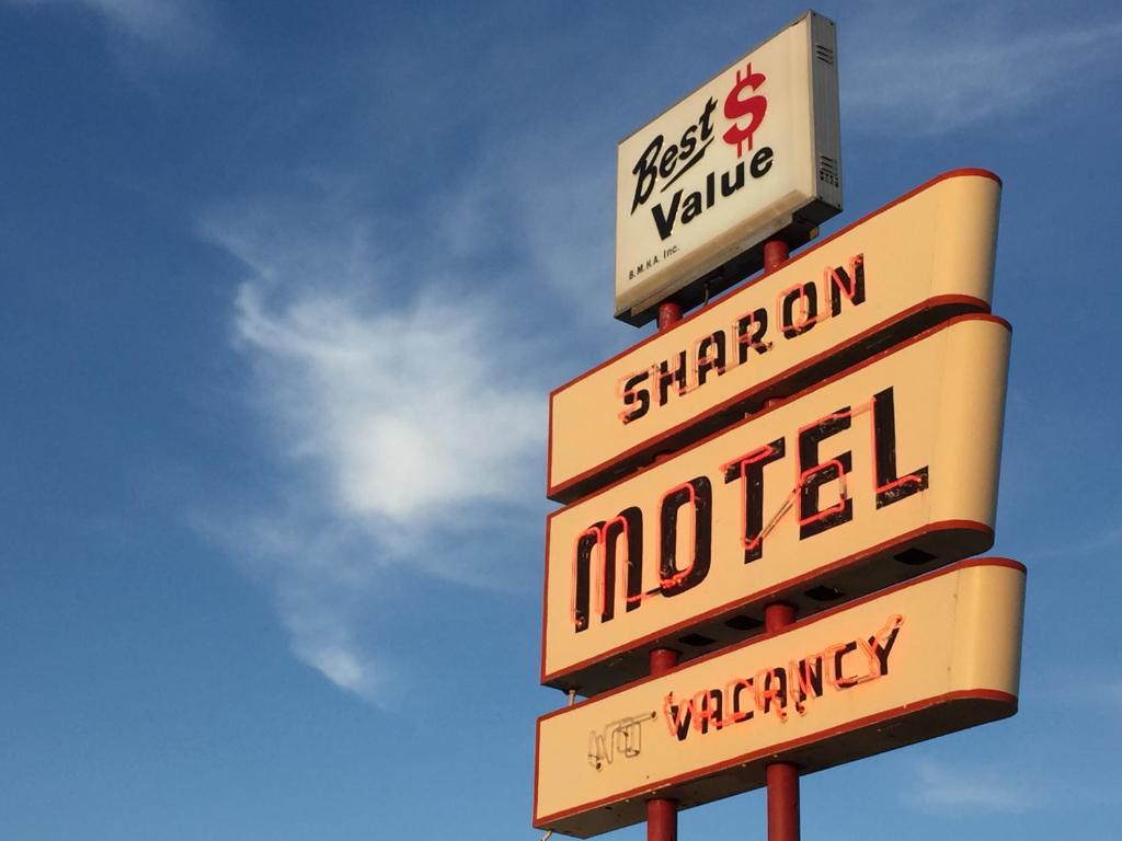 una señal para una gasolinera con señales en ella en Sharon Motel, en Wells