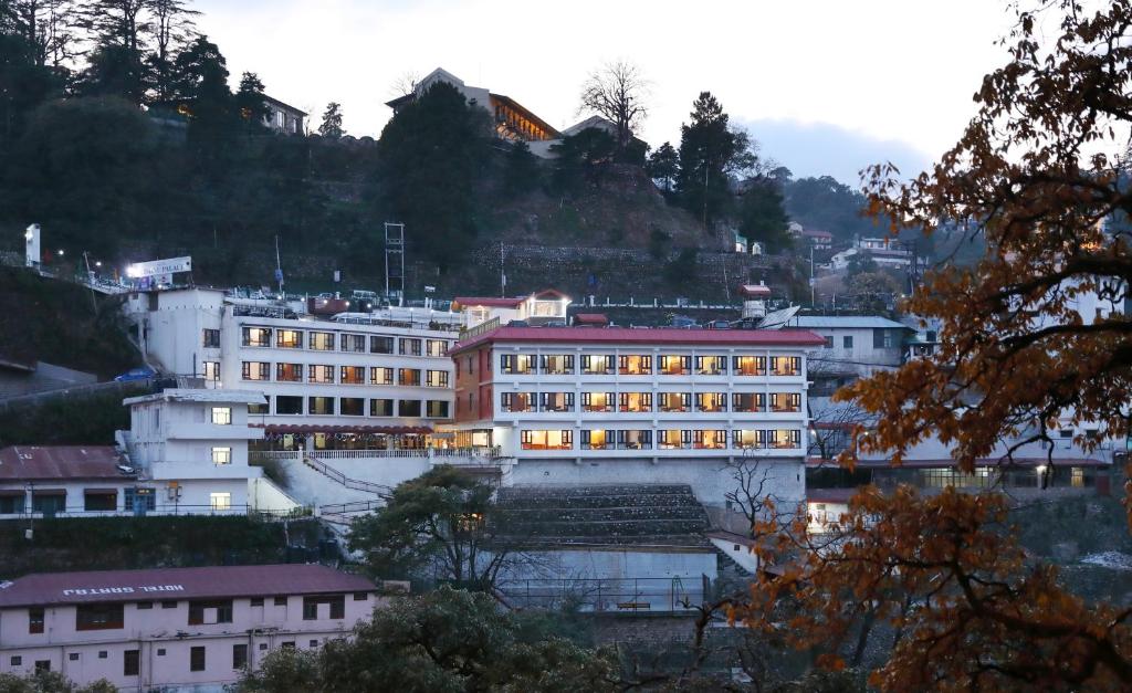 a large building with lights on in a city at Hotel Vishnu Palace in Mussoorie