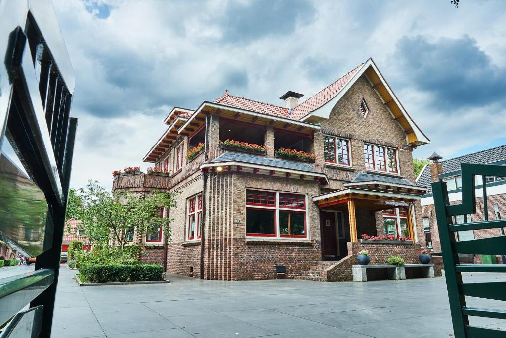 un gran edificio de ladrillo con flores en el balcón en Guesthouse Villa Emmen, en Emmen