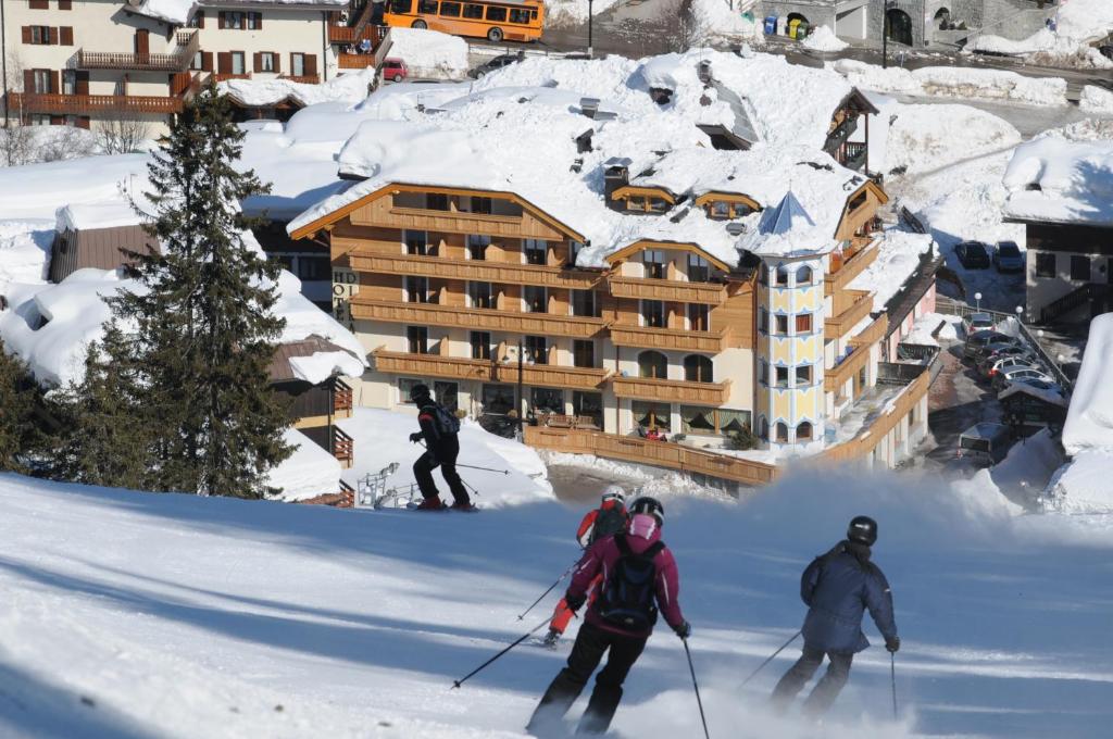 un gruppo di persone che sciano su una pista innevata di Boutique Hotel Diana a Madonna di Campiglio