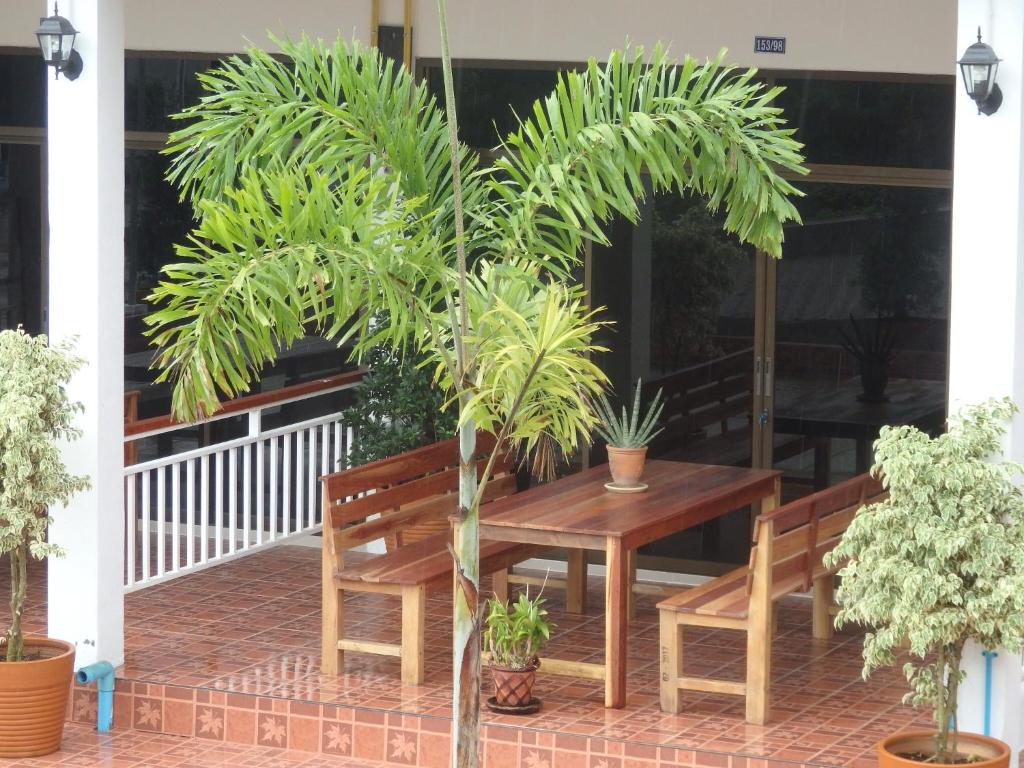 una mesa y dos bancos y una palmera en un porche en Maria's 2 bedroom home for up to 6 people, en Ko Samed