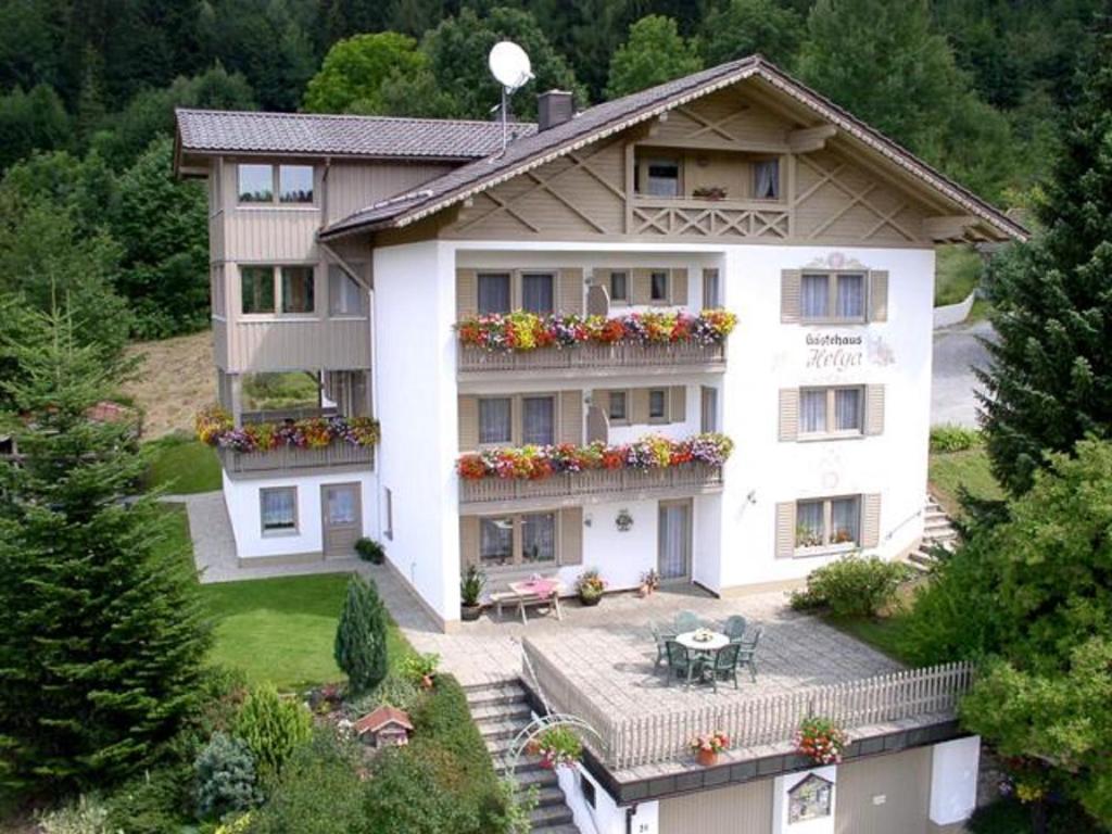 een groot wit gebouw met bloemen op de balkons bij Gastehaus Helga in Bodenmais