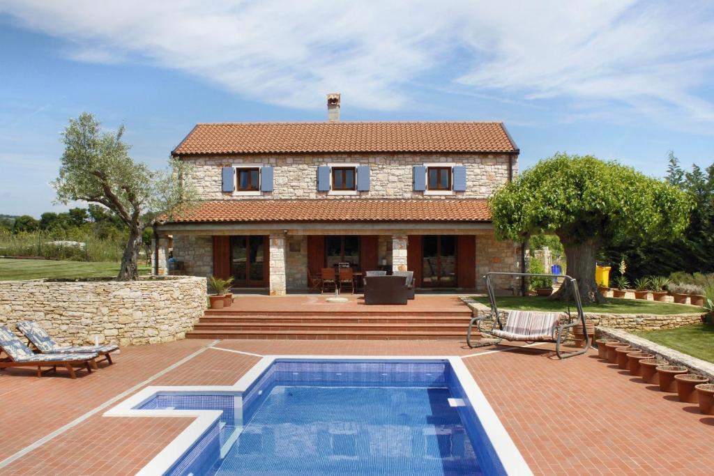 una villa con piscina di fronte a una casa di Mon Perin Castrum - House of Nice Memories a Bale (Valle)