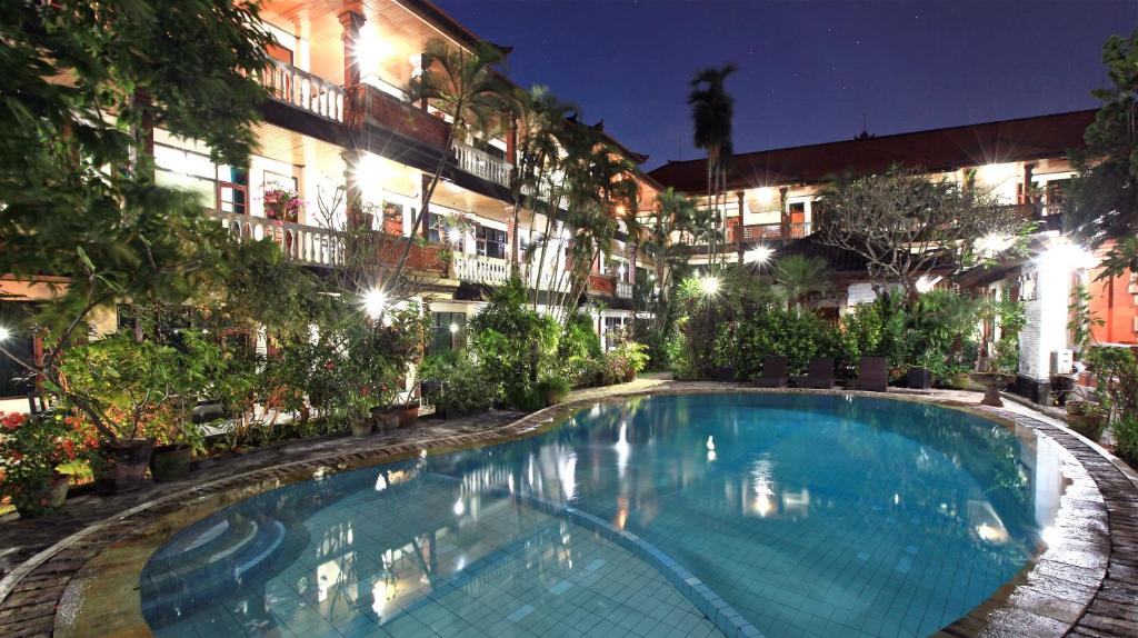 - une piscine en face d'un bâtiment la nuit dans l'établissement Kuta Dormitory at Simpang inn, à Legian
