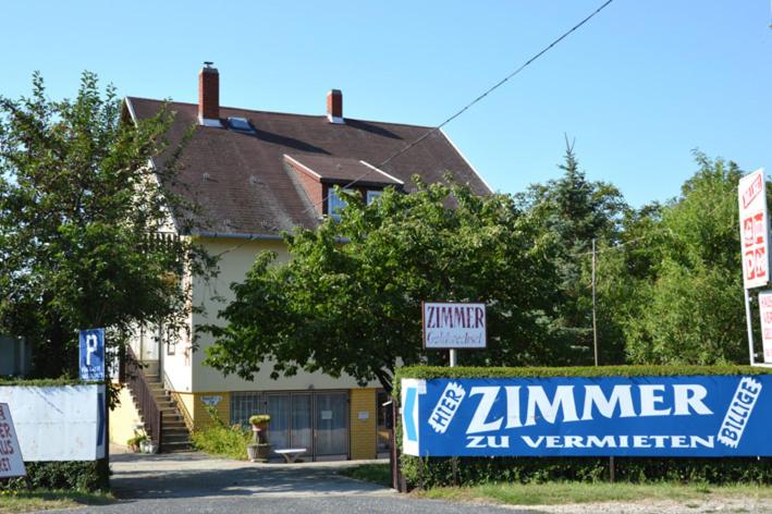 une maison avec un panneau devant une maison dans l'établissement Benedekné Háza, à Gyenesdiás