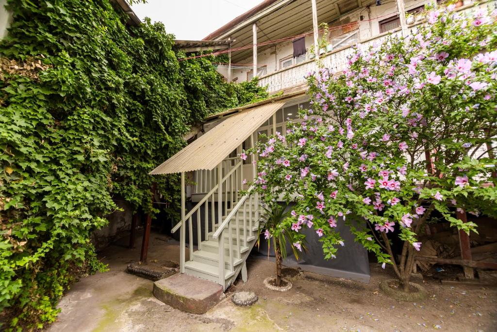 un edificio con una scala accanto ad alcuni fiori di Apartment in Cozy Little Yard a Tbilisi City