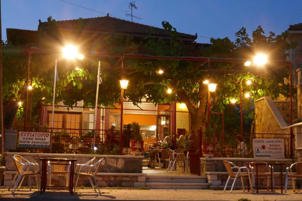 a restaurant with tables and chairs at night at Porto Sabatiki in Sampatiki
