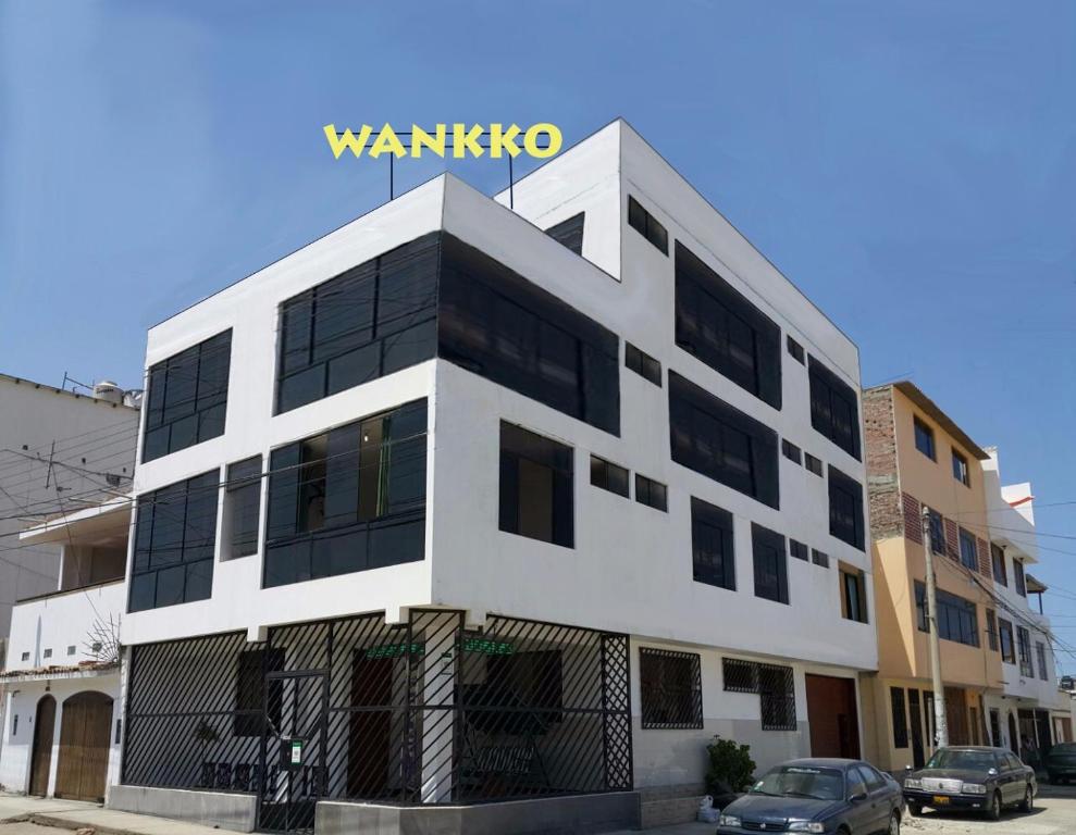 un edificio blanco con un cartel encima en Hospedaje Wankko, en Huanchaco