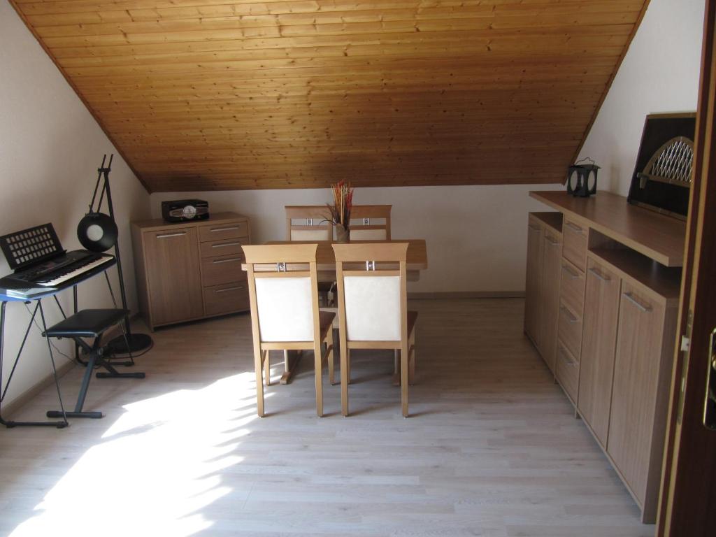 een keuken met een tafel en stoelen en een bureau bij Ferienwohnung Wohlfeld in Habighorst