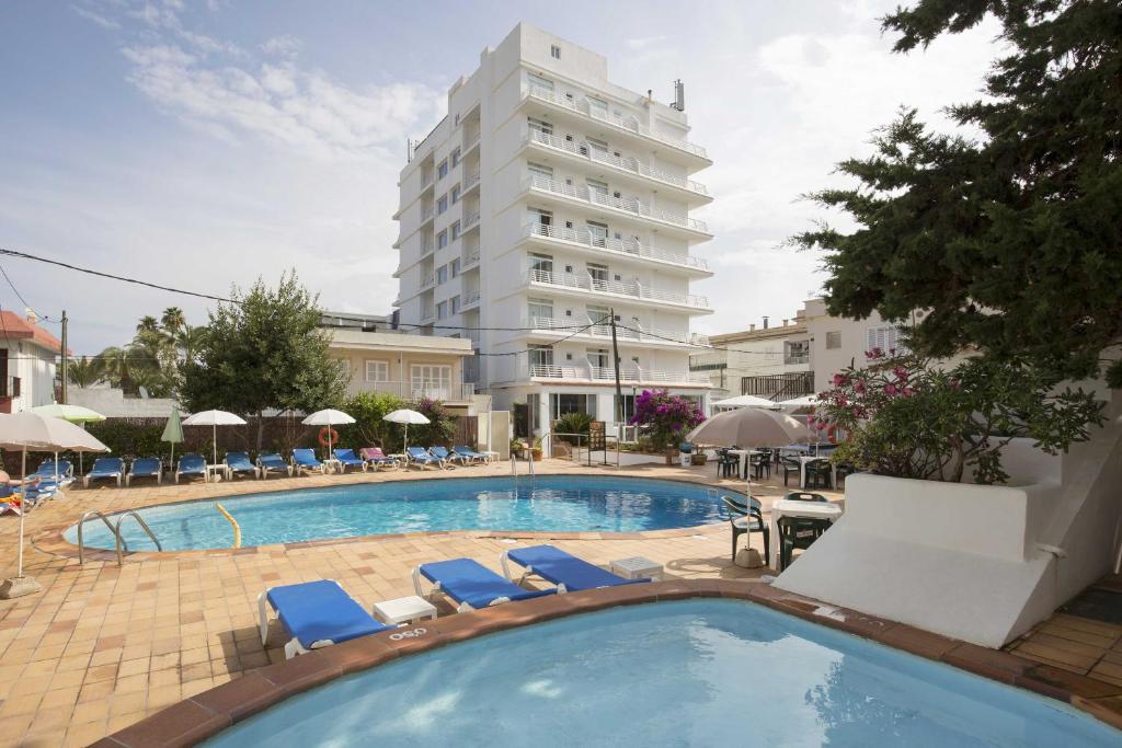 una gran piscina con sillas y un edificio alto en Hotel Sultán, en Can Picafort