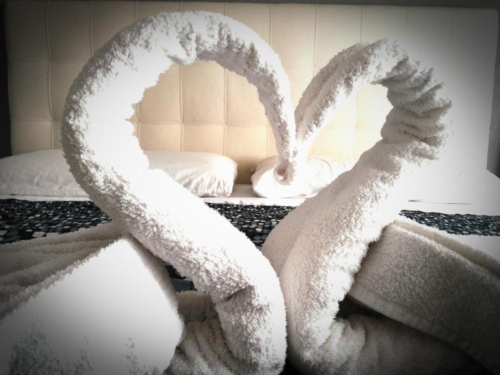 a bed with two towels shaped like hearts at Sweet House Self Check-in 24h in Cavallasca