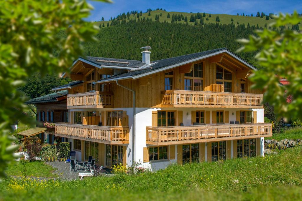 a large wooden house with decks on a hill at Landhaus Bergglühen inkl Bergbahnticket in Oberjoch