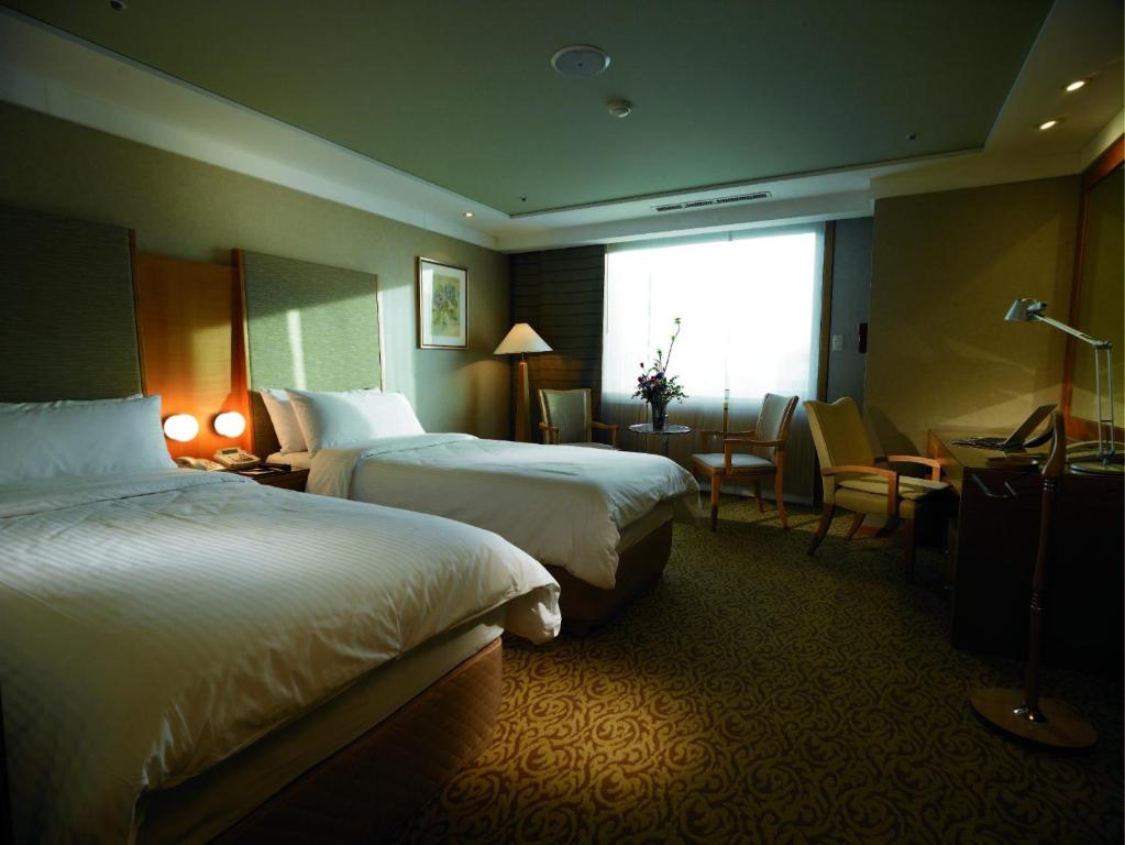 Postel nebo postele na pokoji v ubytování Daegu Grand Hotel