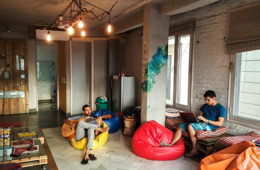 three men sitting on bean bags in a room at JHouse near Bhikaji in New Delhi