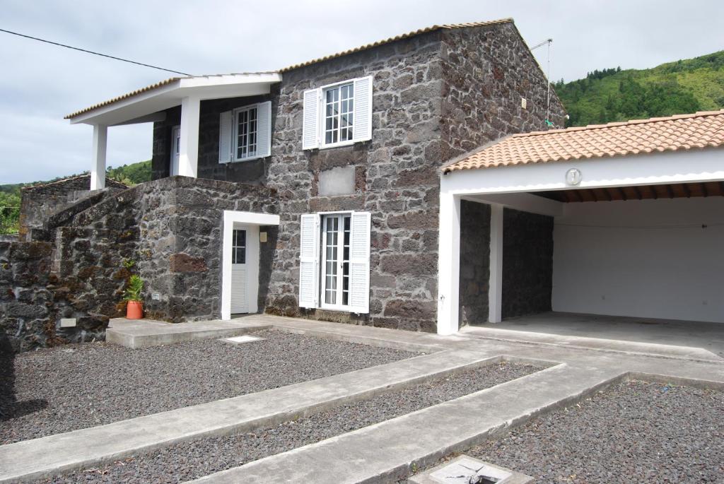 a stone house with a garage in front of it at Casa do Terreiro in Caminho de Cima