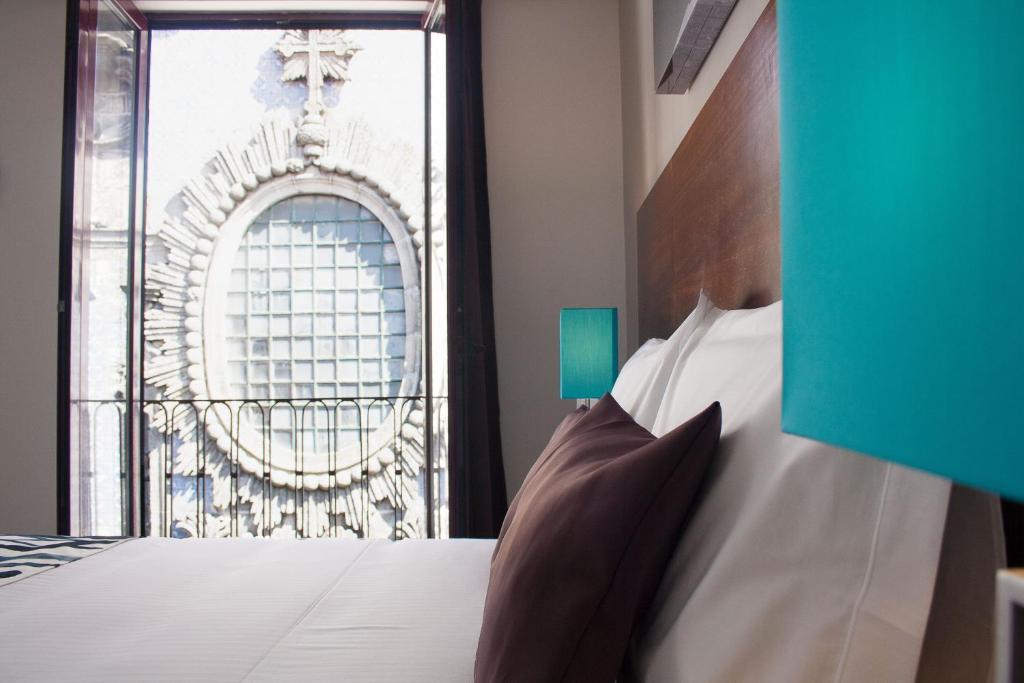 a bedroom with a bed and a window with a building at Nations Porto - Studios & Suites in Porto