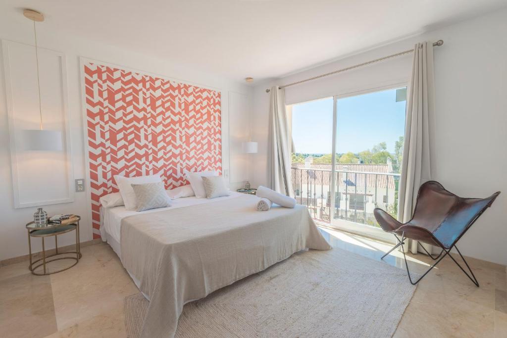 1 dormitorio con cama, silla y ventana grande en VACATION MARBELLA I Nueva Andalucia golf getaway, en Marbella